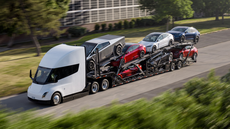 A white Tesla Semi being used a car transporter