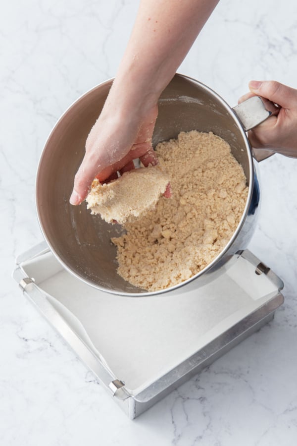 The texture of the shortbread crust will appear dry and crumbly, but will stick together when squeezed.