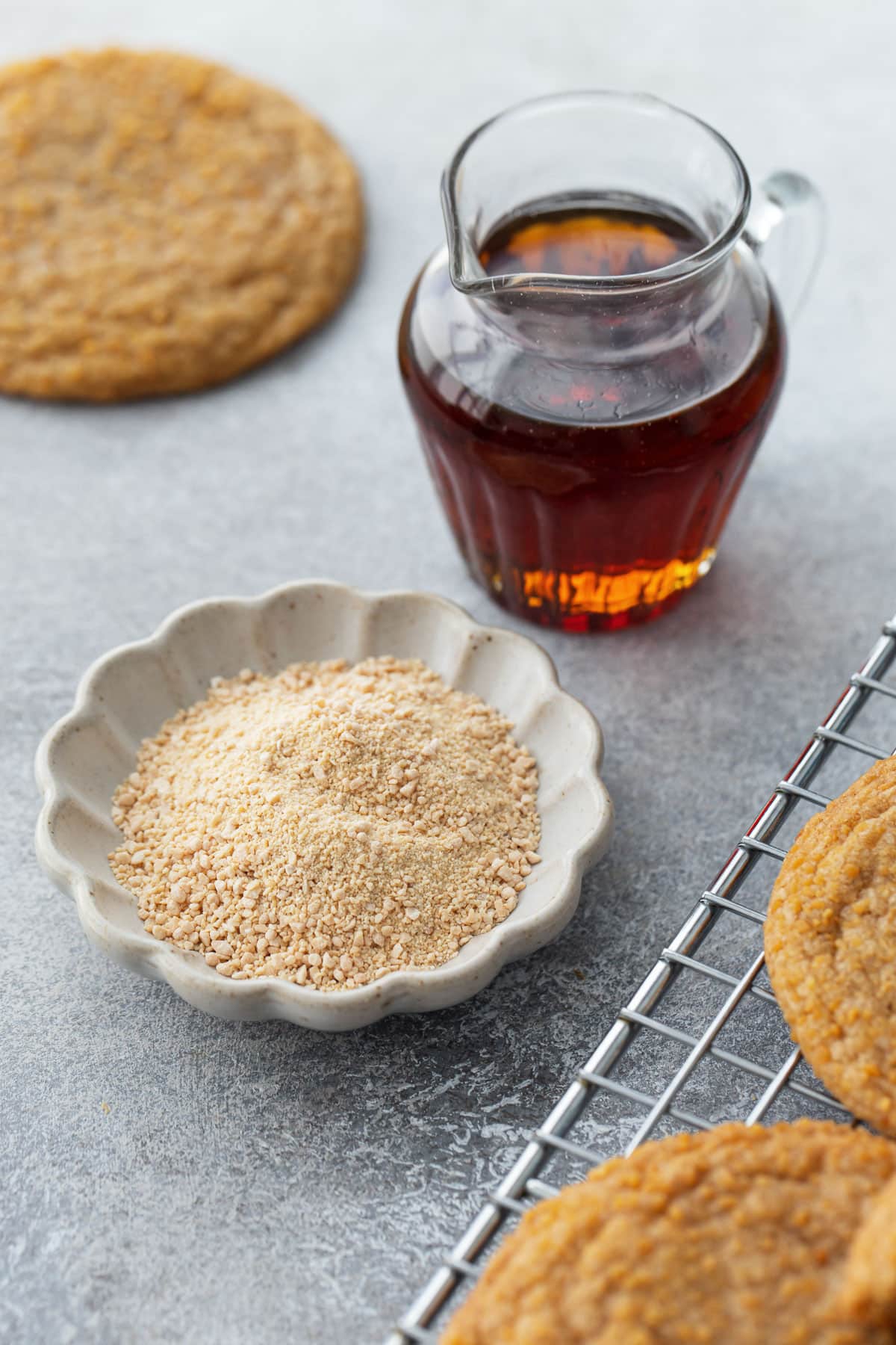 Small glass pitcher with maple syrup, and a small fluted bowl with maple sugar.