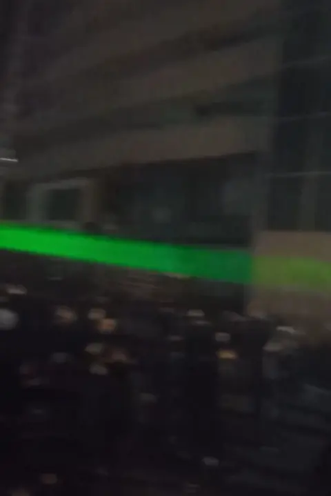 A green laser is seen during a protest in Iran